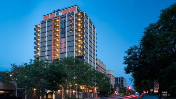 1000 Grant apartment building with lighted balconies at dusk.