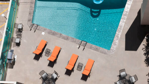 Aerial view of 1000 Grant swimming pool with lounge chairs and dining tables.