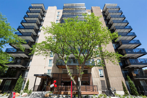 1044 Downing apartment building with large balconies and large trees.