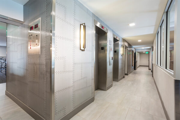 Lobby with riveted metal walls and elevator doors.