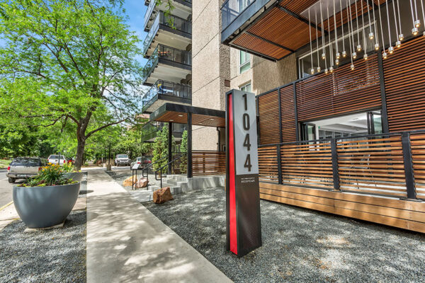 1044 Downing apartment building with large balconies and modern slatted wood additions.