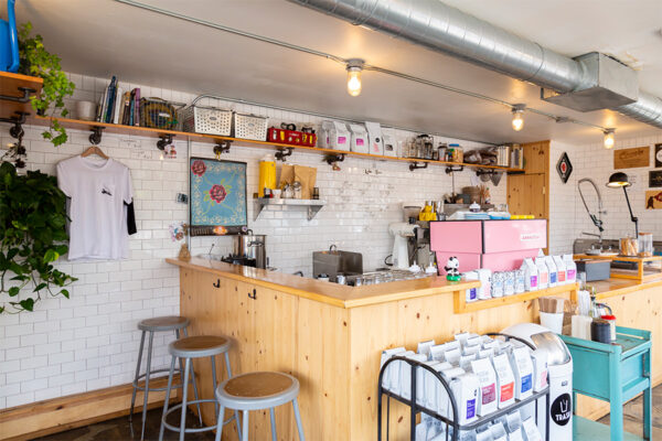 Coffee shop interior with subway tiled walls and coffee making tools.