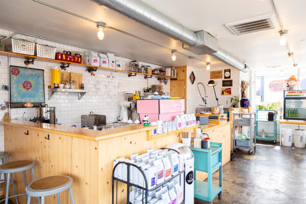 Coffee shop interior with subway tiled walls and counter with bagged coffee.