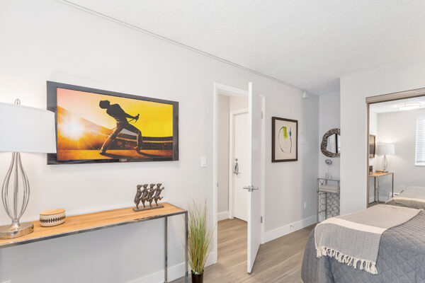 Bedroom with wood floor, clean modern furniture, and wall art.