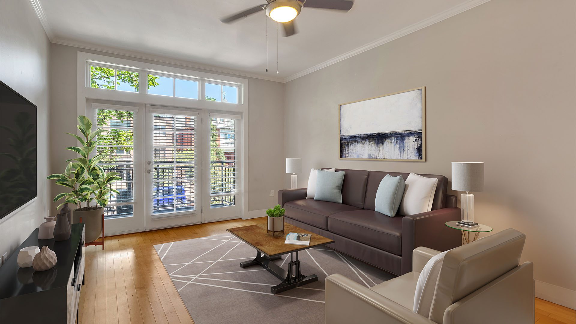 Living room with wood floor, plush furniture, wall mounted TV, and door to balcony.