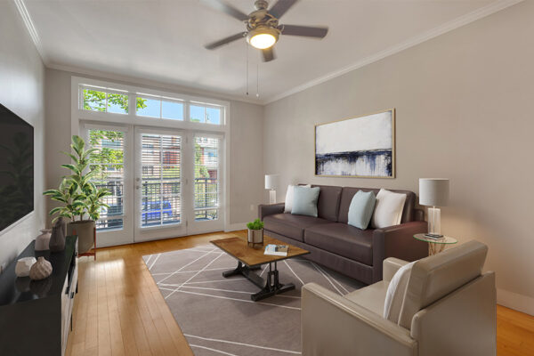 Living room with wood floor, geometric rug, modern furniture, and door to balcony.