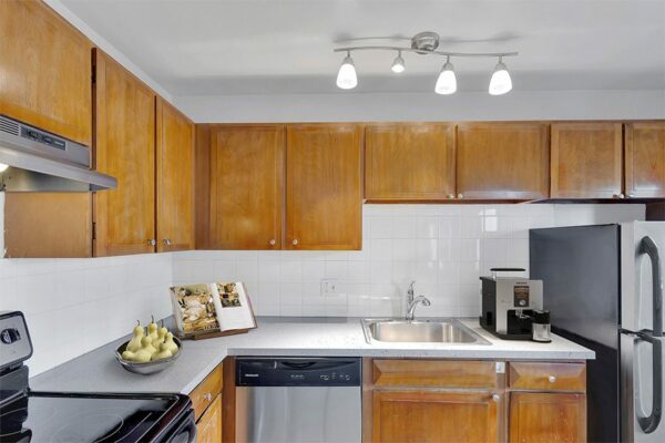Kitchen with wood cabinets, stainless steel appliances, and tiled backsplash.