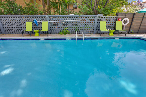 1190 Birch pool with clean blue water and bright green lounge chairs.