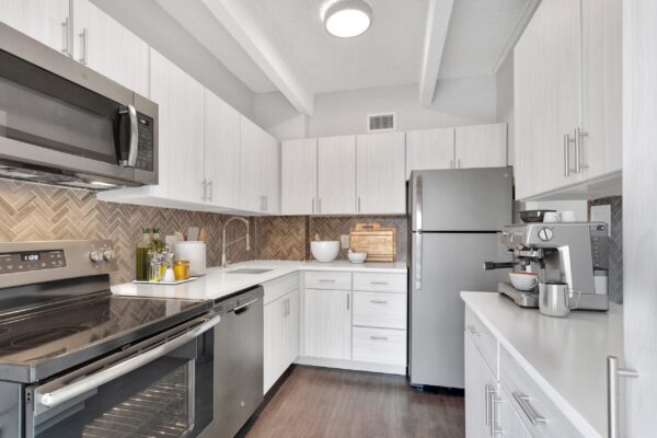 kitchen with white countertops, stainless steel appliances, designer backsplash, and luxury finishes