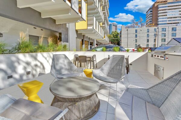 Balcony with metal railing, plush chairs, and door to lounge.