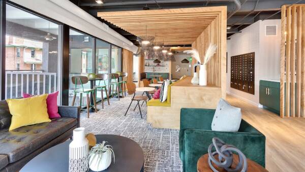 Lounge with decorative wood slats, plush seating, booths with tables and chairs, and glass walls.