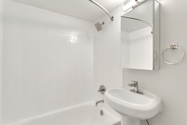 Bathroom with pedestal sink, medicine cabinet, and tiled shower tub.