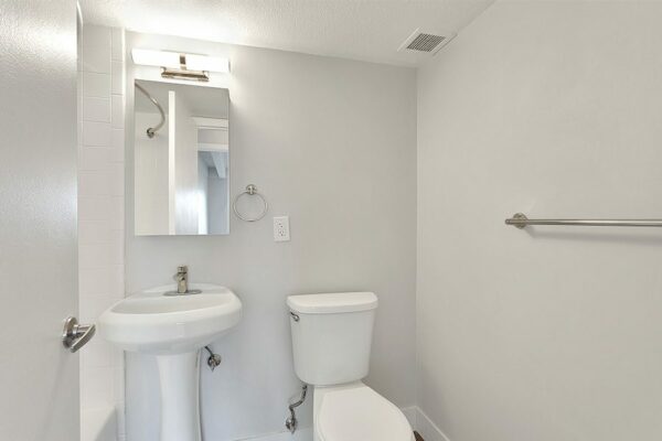 Bathroom with pedestal sink, medicine cabinet, light fixture, and towel bar.