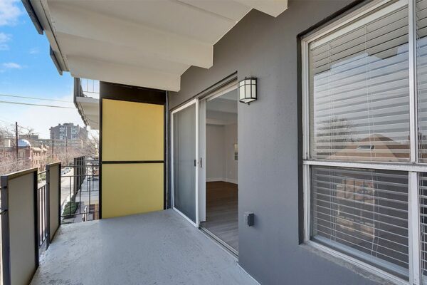 Balcony with modern railings and sliding door to apartment.