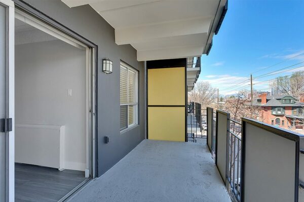 Balcony with modern railings and sliding door to apartment.