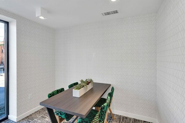 Meeting with carpet, wood table, and comfortable office chairs.