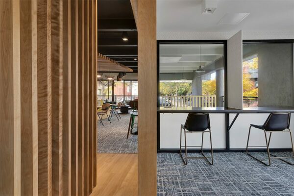 Lounge with decorative wood panels, ample seating, and geometric carpet.