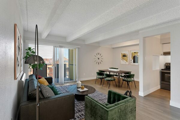 Living area with wood floors, modern furniture, dining table with chairs, and door to balcony.