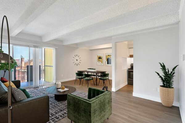 Living area with wood floors, modern furniture, dining table with chairs, and door to balcony.