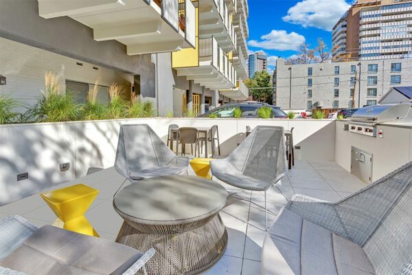 Balcony with metal railing, plush chairs, and door to lounge.
