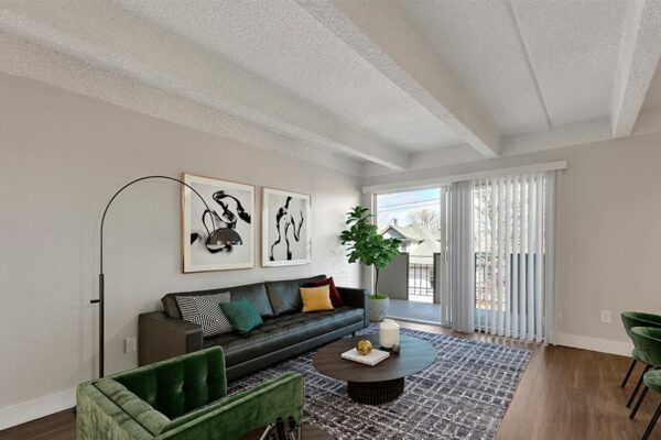 Living room with rug, comfortable modern furniture, floor standing lamp, artwork, and sliding door to balcony.