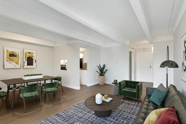 Living area with wood floors, modern furniture, dining table with chairs, and door to kitchen.
