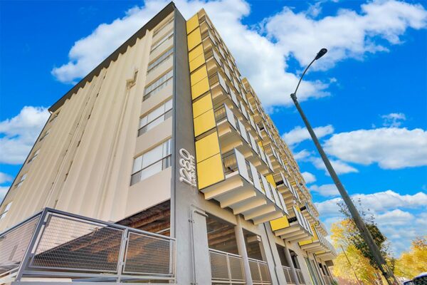 1280 Lafayette apartments with lush landscaping and modern architecture under cloudy skies.