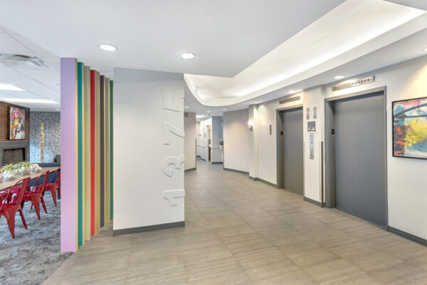 Lobby with wood floor, colorful eclectic decor, and large elevator doors.
