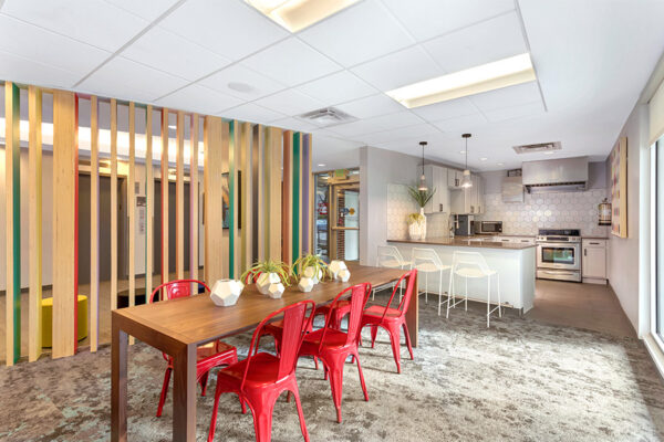 Community kitchen and dining area with dining table, breakfast bar, and kitchen with oven.