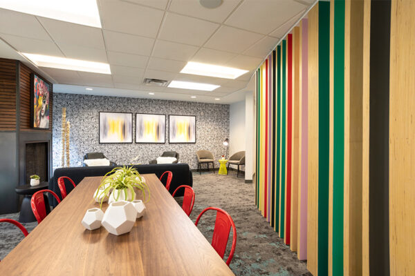 Lounge with carpet, modern furniture, built in fireplace, and colorful decorative slats.
