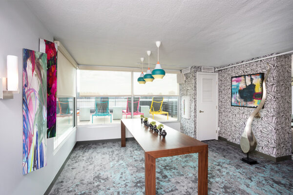Lounge with carpet, eclectic decor and artwork, large sculpture, and large windows.