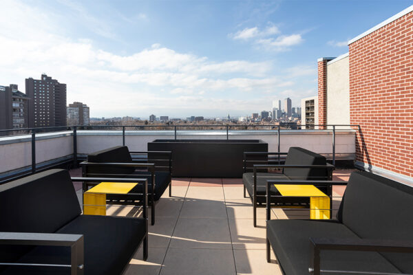 Rooftop patio with modern plush lounge chairs overlooking Denver.