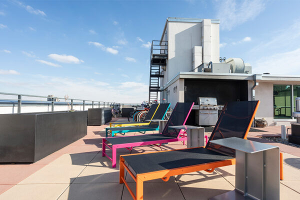 Rooftop patio with colorful lounge chairs overlooking Denver.