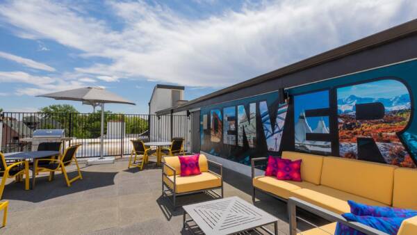 Rooftop patio with comfortable lounge chairs and painted Denver mural.