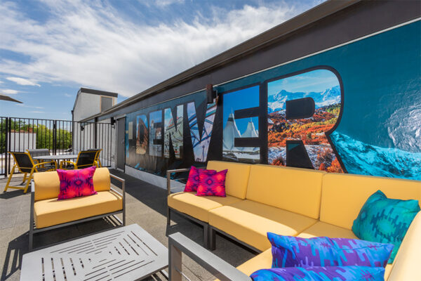 Rooftop patio with plush outdoor sectional and Denver mural.