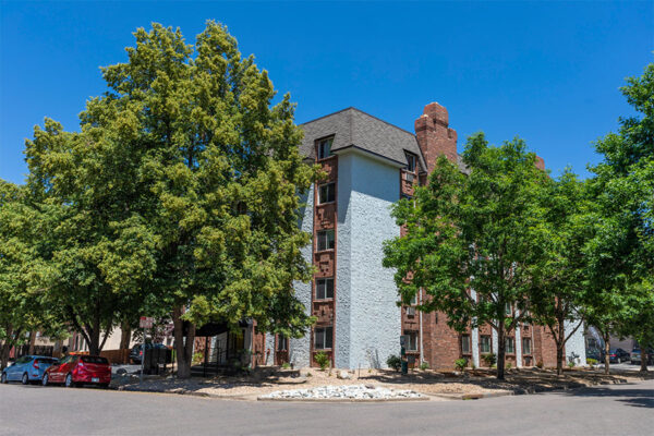 1402 Race apartments with classic construction, tall trees, and street parking.