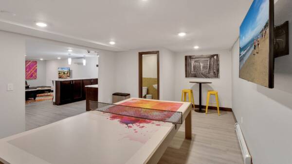 indoor amenity space with ping pong table, tv, and a shared kitchen