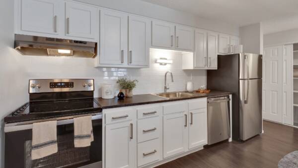 kitchen with white cabinets, white tile backsplash, and stainless steele appliances