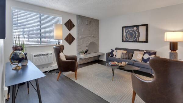 living room with couch, vintage fire place, and large window