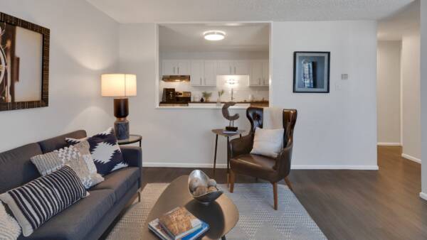 large living room with couch, additional seating chairs, and breakfast nook window to kitchen
