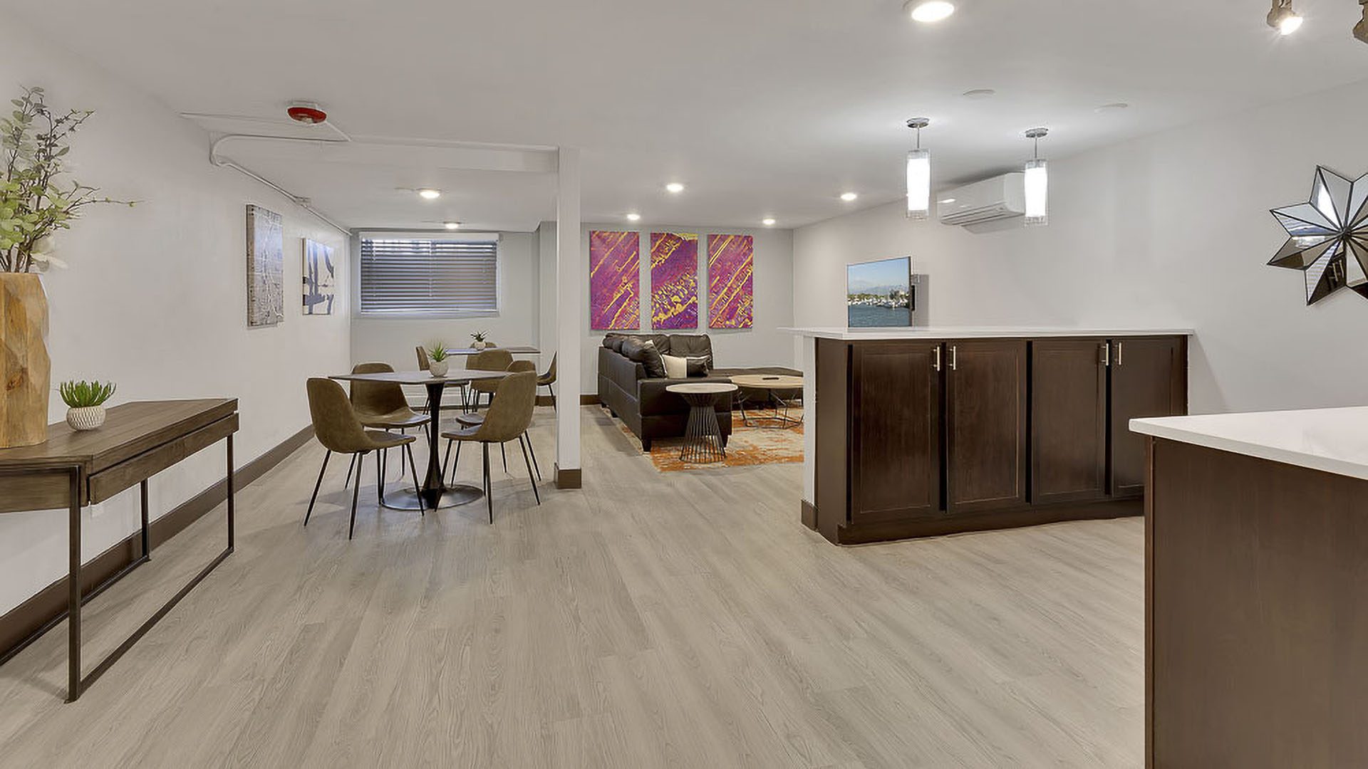 Living area with wood floors, dining table, modern furniture, and lighting fixtures.