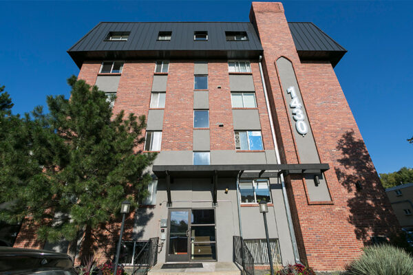 Front of 1430 Humboldt showing entrance door, apartment windows, and large trees.