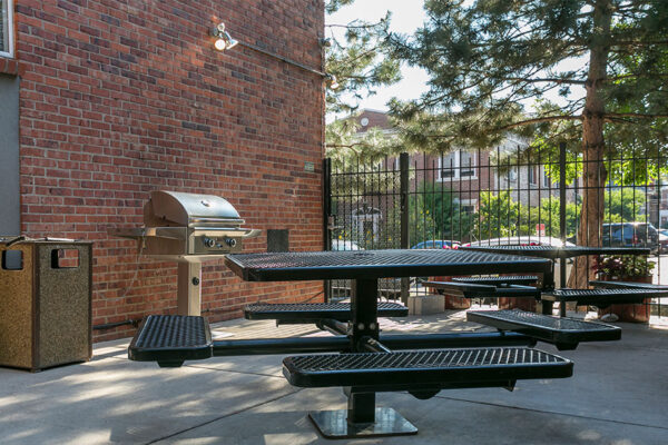 Patio at 1430 Humboldt with built in picnic tables and BBQ grills under shady trees.