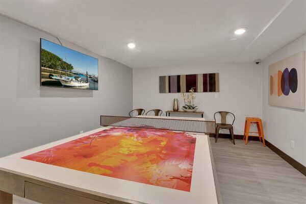 1430 Humboldt game room with table tennis, large TV, and bar tables with stools.