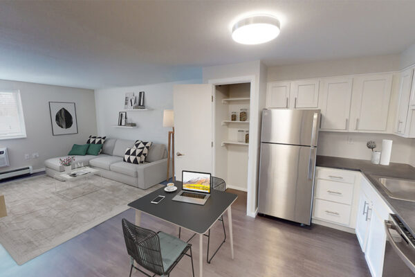 1430 Humboldt apartment living and kitchen space with wood floors, white cabinets, plush seating, and stainless steel appliances.