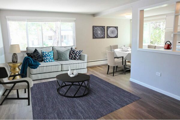 Living room rendering with plush furniture, dining table, framed artwork, and large windows.