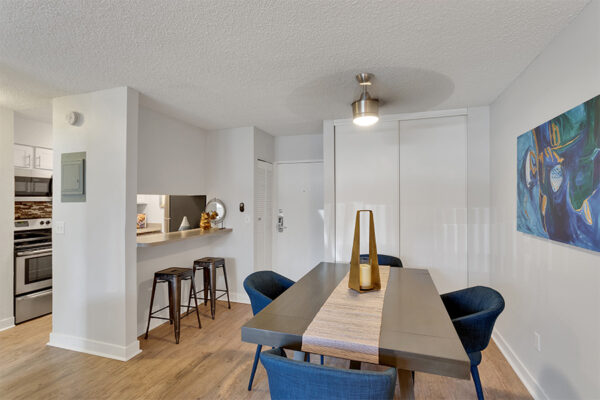 Dining room with wood floor, modern dining table with fabric chairs, and ceiling fan.