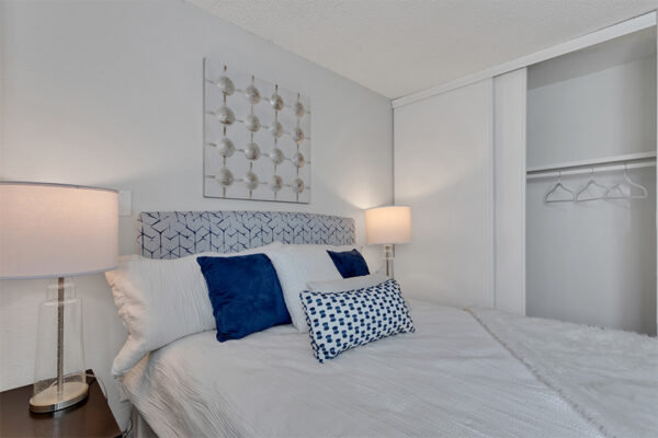 Bedroom with platform bed, bedside tables with lamps, and wall art.