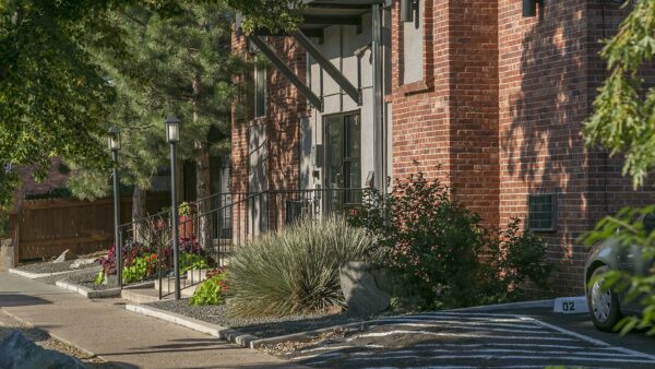 Exterior of 1430 Humboldt with brick construction, lush landscaping, and tall trees.