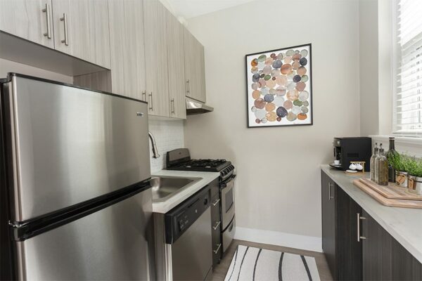 Kitchen with gray cabinets, stone counters, and stainless steel appliances.